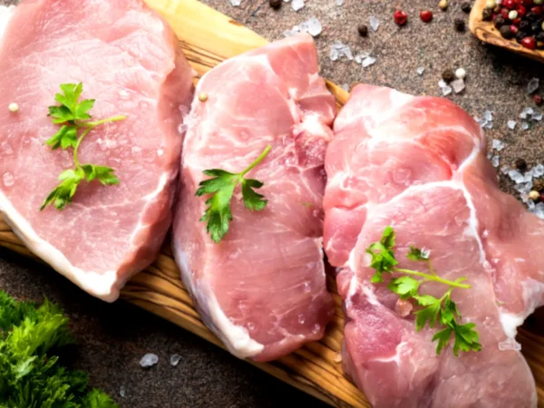 raw boston butt pork steaks on cutting board